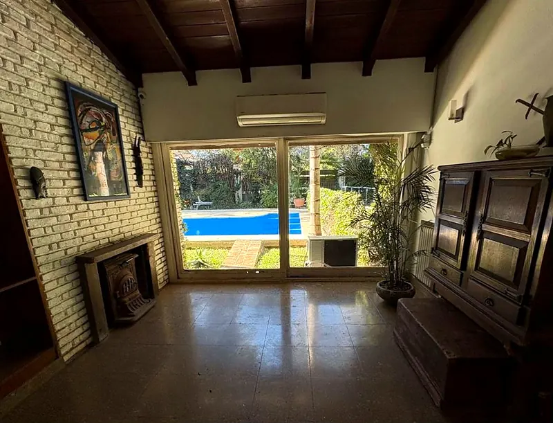 Living de la casa con ventanal que da a la pileta
